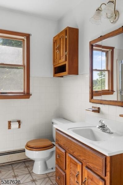 150 Buckley Ave, Oxford Twp, NJ 07863 - bathroom with baseboard heating, tile walls, vanity, plenty of natural light, and a shower with door