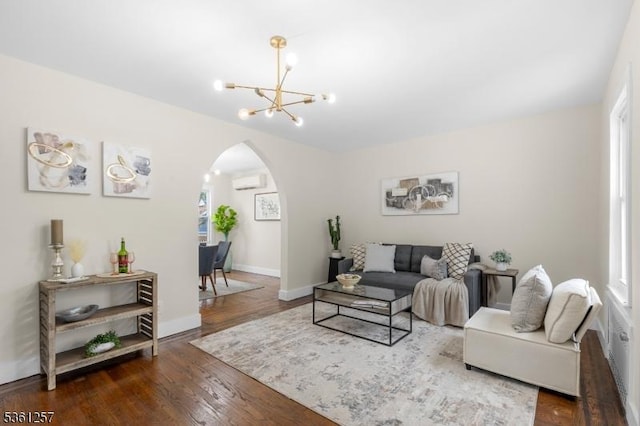 910 Caldwell Ave, Union Twp, NJ 07083 - living room featuring arched walkways, a chandelier, a wall unit AC, wood finished floors, and plenty of natural light