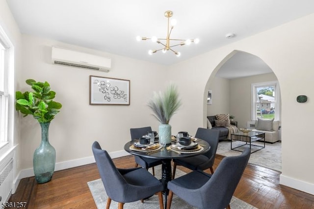 910 Caldwell Ave, Union Twp, NJ 07083 - dining area featuring an AC wall unit, arched walkways, a chandelier, wood finished floors, and radiator heating unit