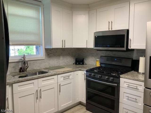 116 Mapes Ave Unit 3, Newark City, NJ 07112 - kitchen featuring appliances with stainless steel finishes, white cabinetry, decorative backsplash, and light stone countertops
