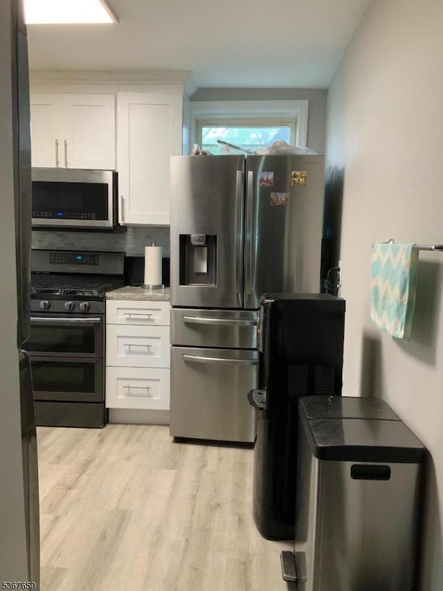 116 Mapes Ave Unit 3, Newark City, NJ 07112 - kitchen featuring stainless steel appliances, white cabinets, and light wood-style flooring