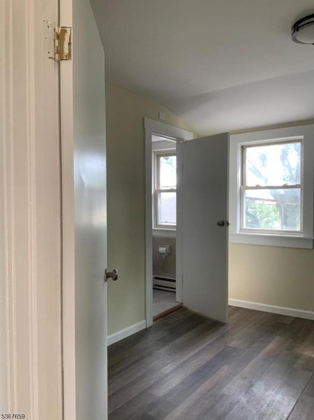 116 Mapes Ave Unit 3, Newark City, NJ 07112 - unfurnished bedroom with vaulted ceiling, a baseboard heating unit, dark wood-style flooring, and multiple windows