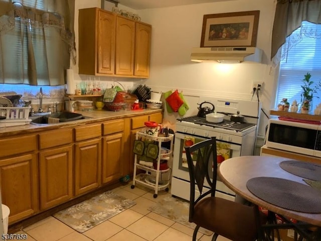 116 Mapes Ave Unit 3, Newark City, NJ 07112 - kitchen featuring under cabinet range hood, white appliances, light tile patterned floors, light countertops, and brown cabinetry