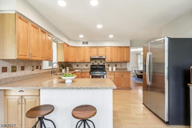 211 Woods End Dr, Bernards Twp, NJ 07920 - kitchen featuring appliances with stainless steel finishes, a peninsula, light wood-style flooring, tasteful backsplash, and light stone countertops