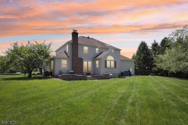 211 Woods End Dr, Bernards Twp, NJ 07920 - back of house at dusk featuring a chimney, a lawn, and a patio area