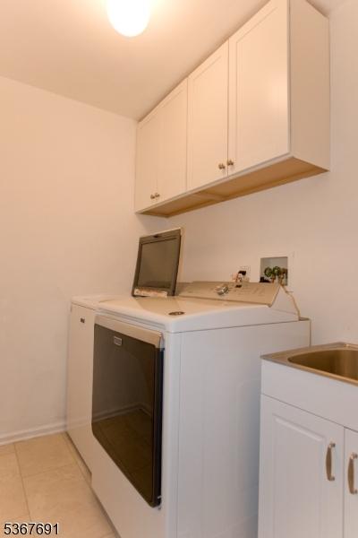425 Diablo Ct, Mahwah Twp, NJ 07430 - washroom with washer and clothes dryer, cabinet space, and light tile patterned floors