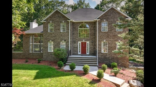 4 Lindsay Ln, Sparta Twp, NJ 07871 - view of front of home featuring a front yard, a chimney, and brick siding