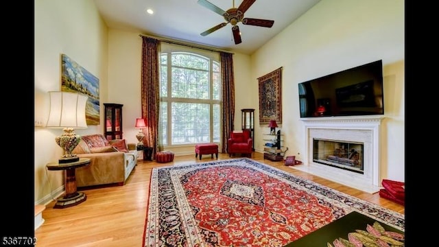 4 Lindsay Ln, Sparta Twp, NJ 07871 - living room featuring a ceiling fan, a fireplace with flush hearth, wood finished floors, recessed lighting, and a high ceiling