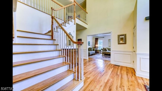 4 Lindsay Ln, Sparta Twp, NJ 07871 - stairway featuring a towering ceiling, wood finished floors, wainscoting, and a decorative wall
