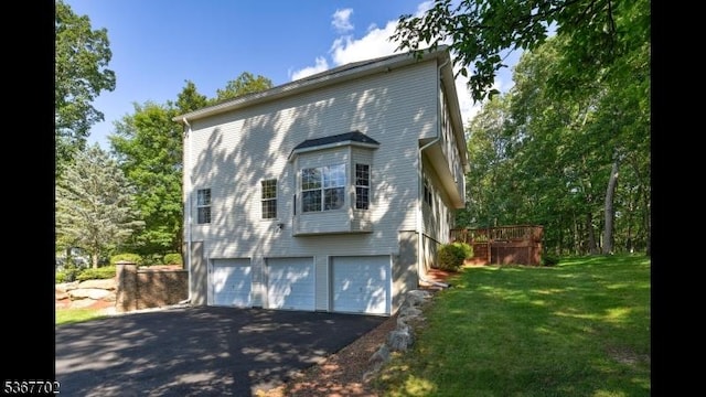 4 Lindsay Ln, Sparta Twp, NJ 07871 - view of side of home featuring asphalt driveway, a garage, and a lawn