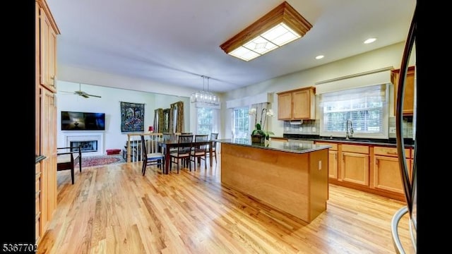 4 Lindsay Ln, Sparta Twp, NJ 07871 - kitchen with dark countertops, black fridge, a fireplace, a kitchen island, and light wood-style flooring