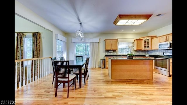 4 Lindsay Ln, Sparta Twp, NJ 07871 - kitchen featuring stainless steel appliances, decorative backsplash, a center island, dark countertops, and light brown cabinets