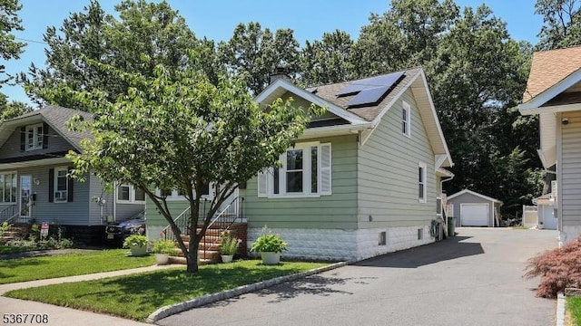114 Oakley St, Roselle Boro, NJ 07203 - view of front facade with a detached garage, an outbuilding, solar panels, a chimney, and a front lawn
