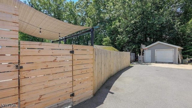 114 Oakley St, Roselle Boro, NJ 07203 - view of property exterior with a detached garage, driveway, and an outdoor structure