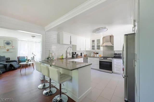 114 Oakley St, Roselle Boro, NJ 07203 - kitchen featuring appliances with stainless steel finishes, a peninsula, crown molding, backsplash, and a kitchen bar
