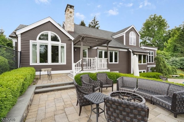 52 W Main St, Mendham Boro, NJ 07945 - back of property featuring a patio area, an outdoor living space with a fire pit, a chimney, a shingled roof, and a pergola