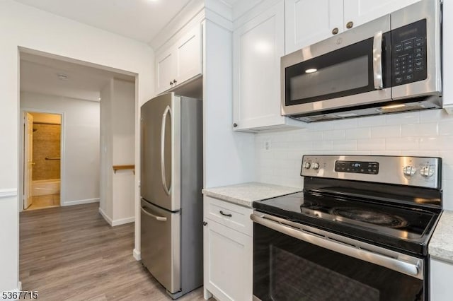255 Glastonbury Ln, Franklin Twp, NJ 08873 - kitchen featuring stainless steel appliances, white cabinetry, light wood-style flooring, tasteful backsplash, and light stone countertops