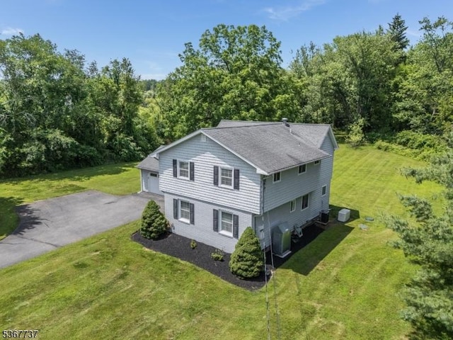 4 Orchid Pl, Clinton Twp, NJ 08833 - view of side of property featuring a lawn, roof with shingles, a garage, and a forest view