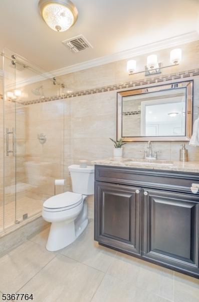 106 Woodbine Cir, New Providence Boro, NJ 07974 - full bathroom featuring crown molding, vanity, tile patterned flooring, a stall shower, and tile walls