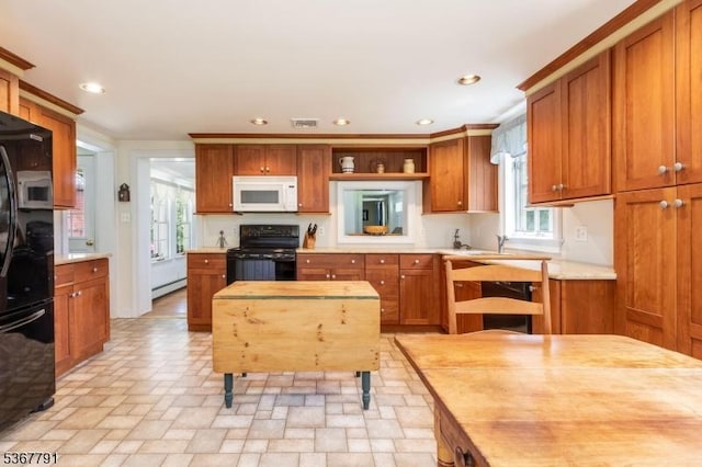30 Bissell Rd, Tewksbury Twp, NJ 08833 - kitchen with white microwave, black stove, fridge, light countertops, and brown cabinets
