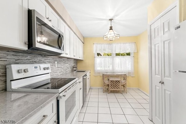 42 Carriage Ln, Sparta Twp, NJ 07871 - kitchen with stainless steel appliances, decorative backsplash, white cabinetry, light tile patterned flooring, and hanging light fixtures