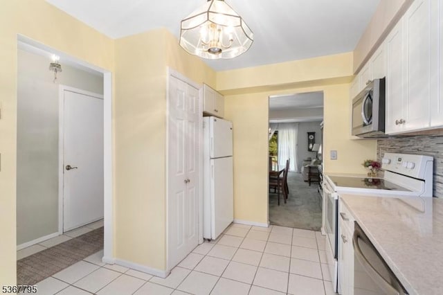 42 Carriage Ln, Sparta Twp, NJ 07871 - kitchen featuring white appliances, a chandelier, light countertops, white cabinetry, and light tile patterned floors