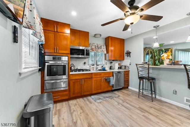 947 Boesel Ave, Manville Boro, NJ 08835 - kitchen with a warming drawer, stainless steel appliances, light countertops, and brown cabinets