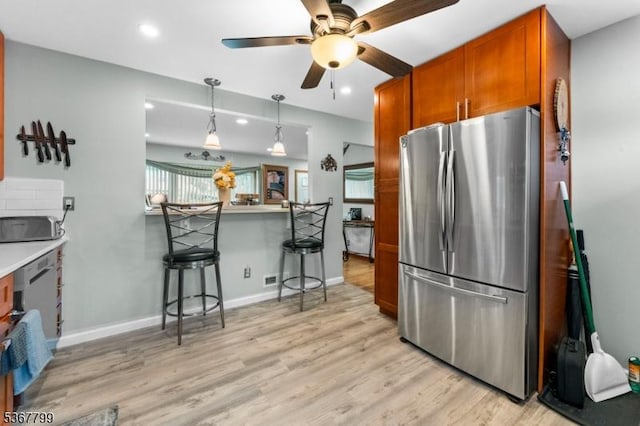 947 Boesel Ave, Manville Boro, NJ 08835 - kitchen featuring freestanding refrigerator, a breakfast bar area, a ceiling fan, brown cabinetry, and light wood finished floors