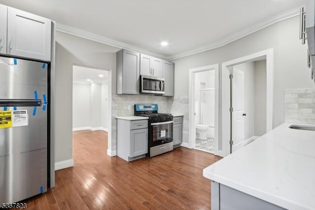 621 Roosevelt Ave, Carteret Boro, NJ 07008 - kitchen featuring stainless steel appliances, gray cabinets, ornamental molding, backsplash, and dark wood-type flooring