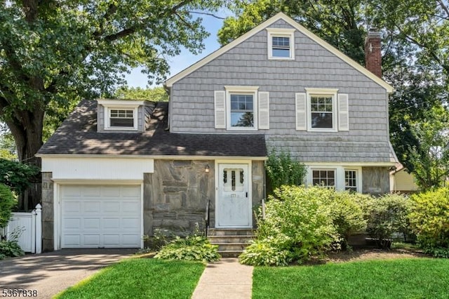 173 Raab Ave, Bloomfield Twp, NJ 07003 - view of front facade with concrete driveway, a chimney, an attached garage, stone siding, and entry steps