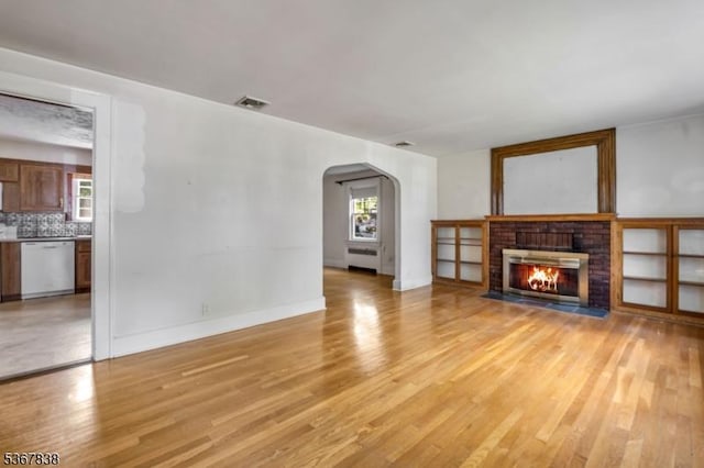 173 Raab Ave, Bloomfield Twp, NJ 07003 - unfurnished living room featuring arched walkways, light wood finished floors, and a fireplace