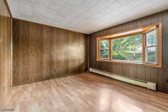 173 Raab Ave, Bloomfield Twp, NJ 07003 - empty room featuring a baseboard heating unit, wooden walls, and light wood-style floors
