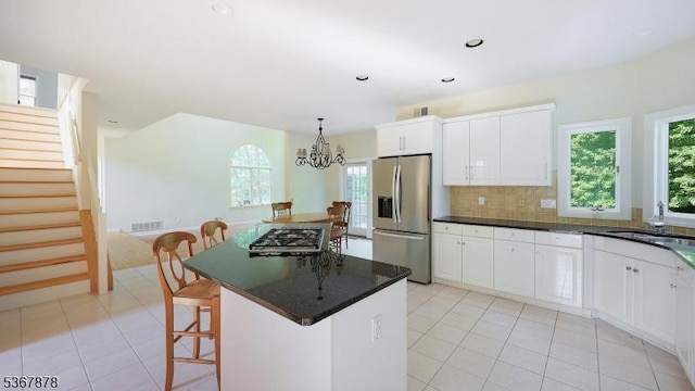 64 Sneider Rd, Warren Twp, NJ 07059 - kitchen with appliances with stainless steel finishes, a kitchen island, a breakfast bar area, light tile patterned flooring, and recessed lighting