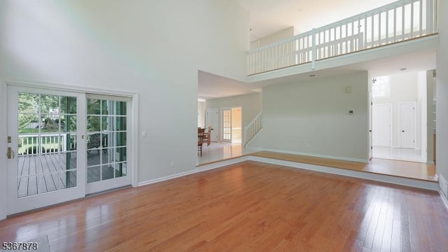 64 Sneider Rd, Warren Twp, NJ 07059 - unfurnished living room featuring stairway, a towering ceiling, and wood finished floors