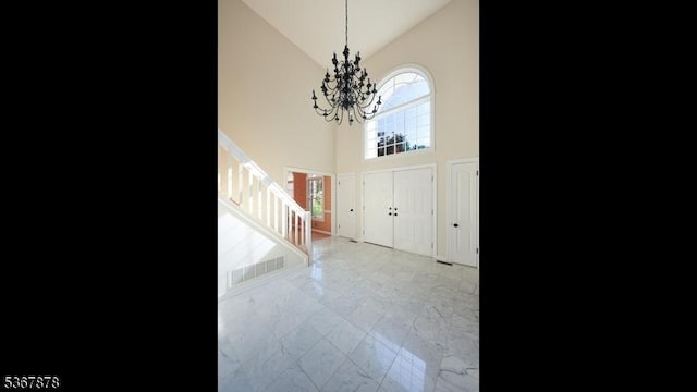 64 Sneider Rd, Warren Twp, NJ 07059 - foyer entrance with high vaulted ceiling, stairs, a chandelier, and marble look tile flooring