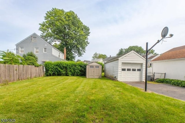 408 Sanford Ave, Hillside Twp, NJ 07205 - view of yard featuring asphalt driveway, a detached garage, and a storage shed