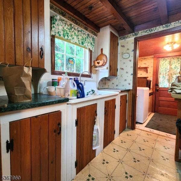 118 Hilltop Trl, Sparta Twp, NJ 07871 - kitchen with a wood ceiling with exposed beams, wallpapered walls, and brown cabinetry