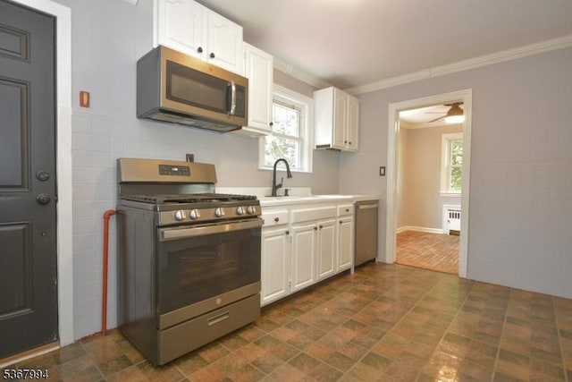 36 Grove St, Waldwick Boro, NJ 07463 - kitchen with appliances with stainless steel finishes, white cabinetry, light countertops, crown molding, and a ceiling fan