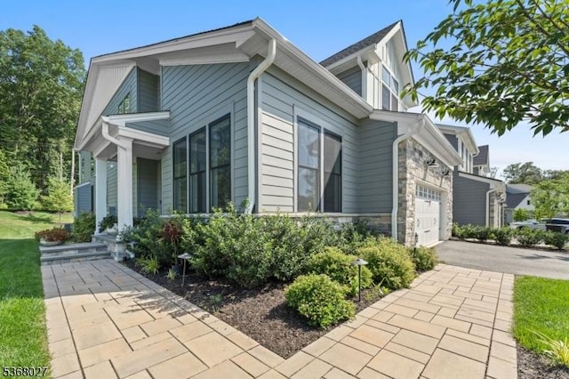 28 Peacock Ln Unit 28, Berkeley Heights Twp, NJ 07922 - view of home's exterior featuring asphalt driveway, a garage, and stone siding
