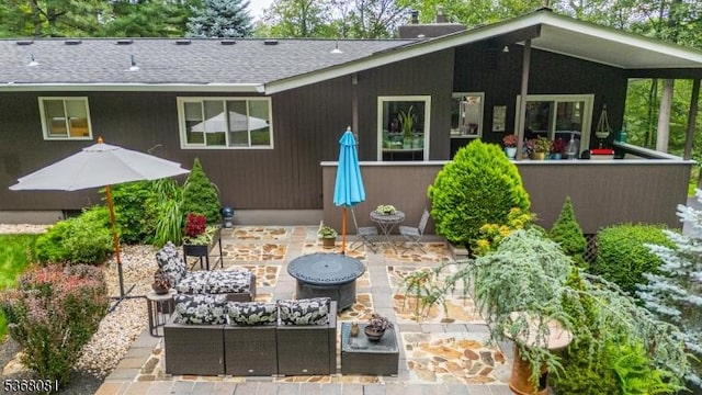 7 Deer Ct, Chester Twp, NJ 07930 - back of house featuring a patio area, outdoor lounge area, a shingled roof, and a chimney