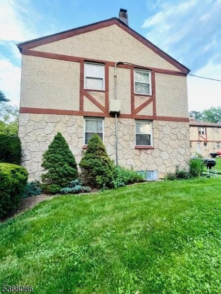 185 High St, Metuchen Boro, NJ 08840 - view of side of property with stone siding, a yard, stucco siding, and a chimney