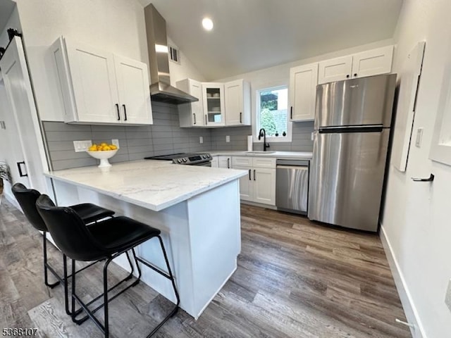 8 Blanche Dr, Jefferson Twp, NJ 07849 - kitchen with appliances with stainless steel finishes, a peninsula, white cabinets, a kitchen bar, and light stone counters