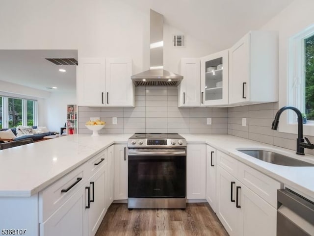 8 Blanche Dr, Jefferson Twp, NJ 07849 - kitchen featuring appliances with stainless steel finishes, wall chimney exhaust hood, a peninsula, white cabinetry, and recessed lighting