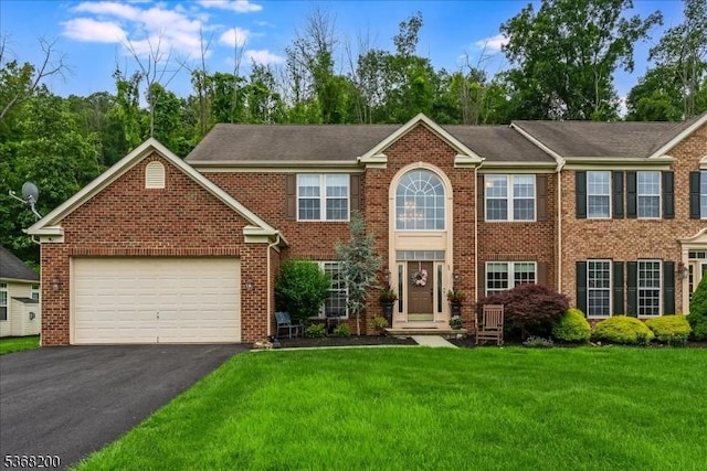 40 Primrose Ln, Sparta Twp, NJ 07871 - view of front of house featuring driveway, a front lawn, a garage, and brick siding