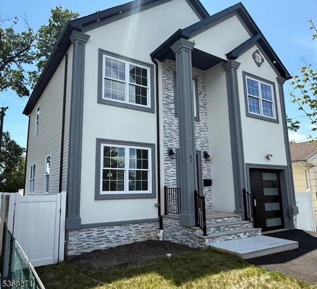 47 Bird Ave, Woodbridge Twp, NJ 08830 - view of front facade featuring stucco siding, stone siding, driveway, and an attached garage