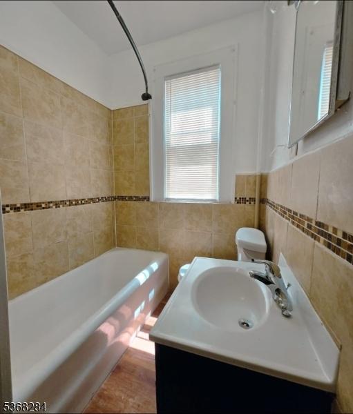 205-207 Chancellor Ave, Newark City, NJ 07112 - bathroom featuring tile walls, shower / bath combination, and vanity