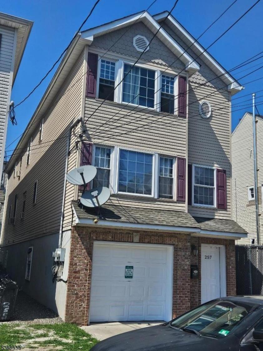257 Governor St Unit 2, Paterson City, NJ 07501 - view of front of house featuring a garage and brick siding