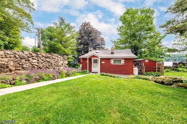 2100 Lakeside Dr, Vernon Twp, NJ 07422 - back of house with a lawn, an outdoor structure, faux log siding, and a chimney