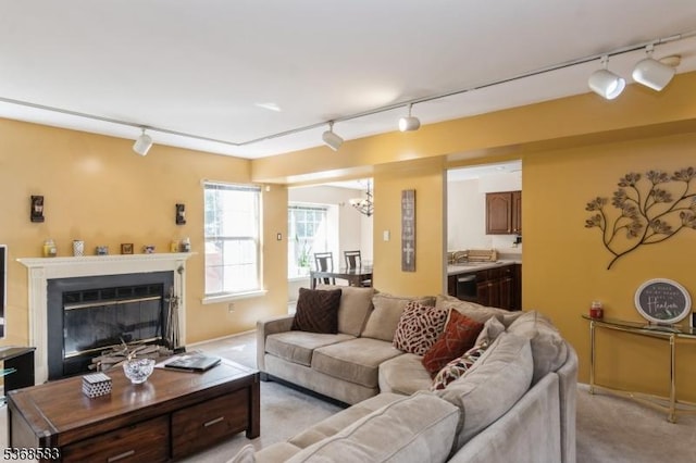 76 Avebury Pl, Franklin Twp, NJ 08873 - living area with track lighting, a chandelier, light carpet, and a glass covered fireplace