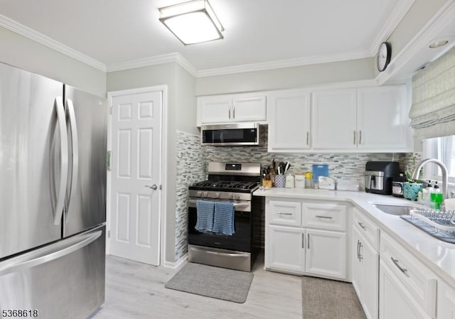 724 Bloomfield Ave, Clifton City, NJ 07012 - kitchen featuring appliances with stainless steel finishes, white cabinets, tasteful backsplash, light countertops, and crown molding